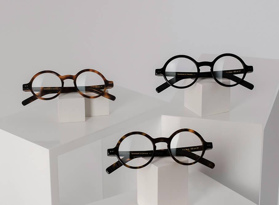 drei lunor korrektionsbrillen auf weissen quadern werden asymetrisch praesentiert